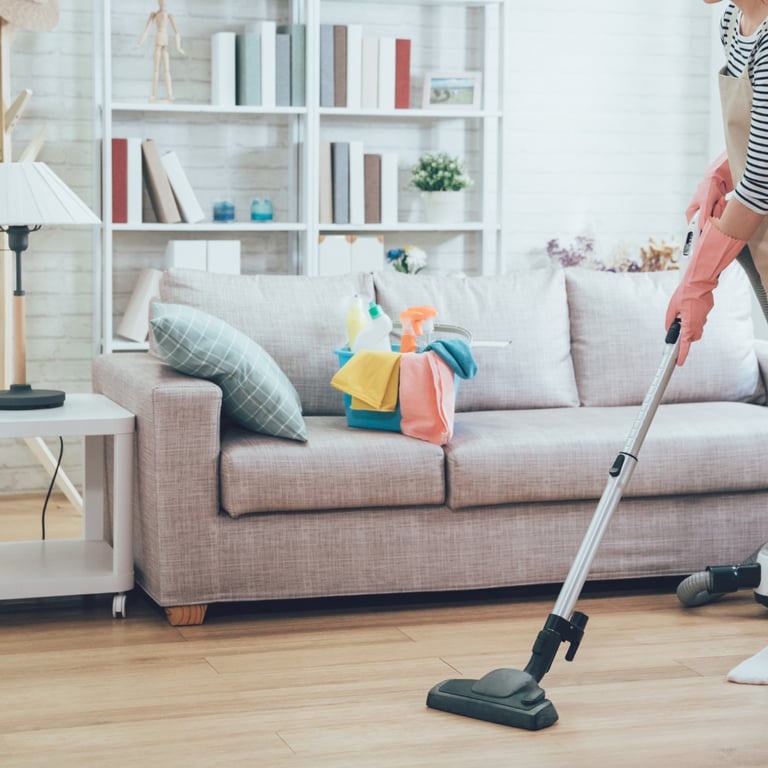 a woman in a striped shirt is cleaning a couch