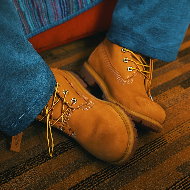 A pair of brown Timberland boot shoes on hotel carpet.