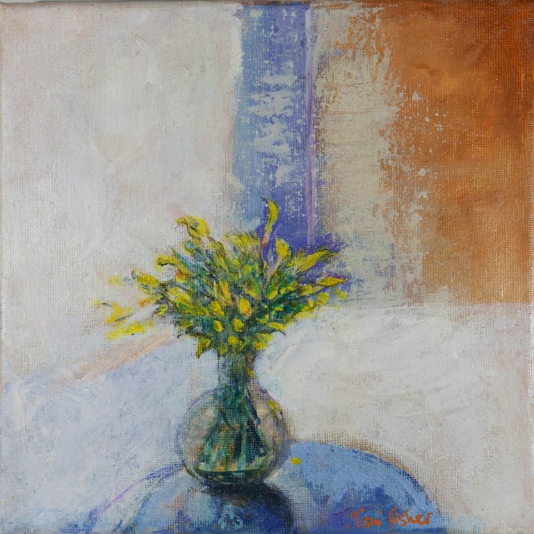 A simple vase of flowers sits on a blue tabletop with an arty backdrop of white blue and orange