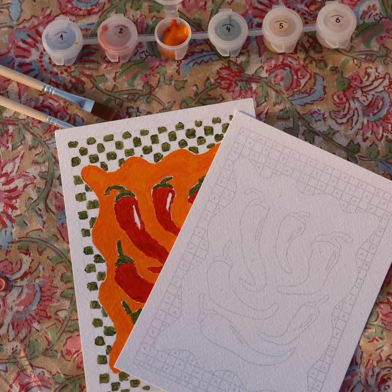 Un kit de peinture par numéros représentant un piment rouge, avec des pinceaux et des pots de peintu