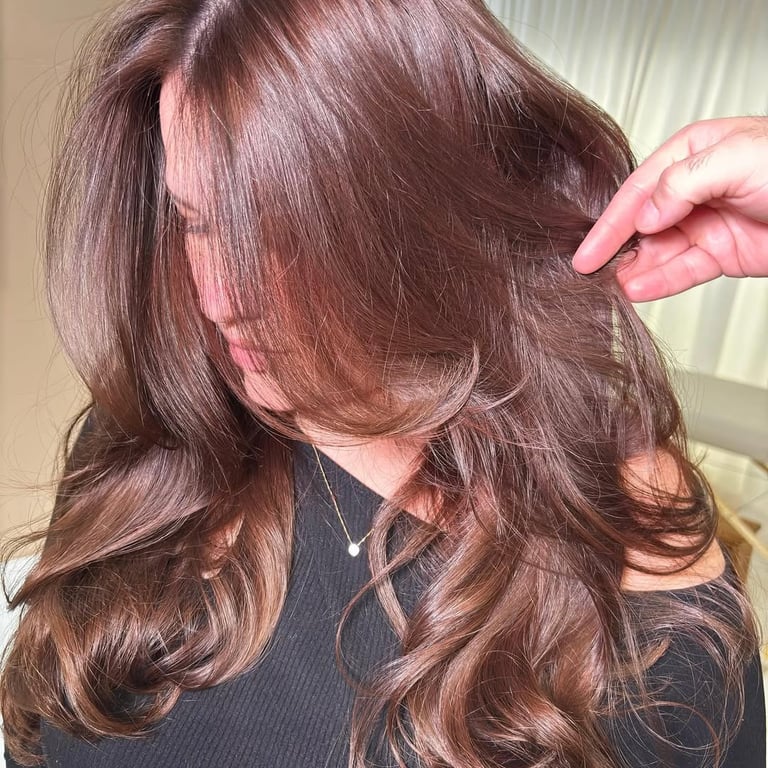 Resultado de coloração no tom castanho iluminado e escova modelada, realçando o brilho e a saúde do cabelo, um serviço do We