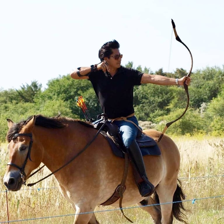 a man is riding a horse with a bow and arrows. equestrian archery