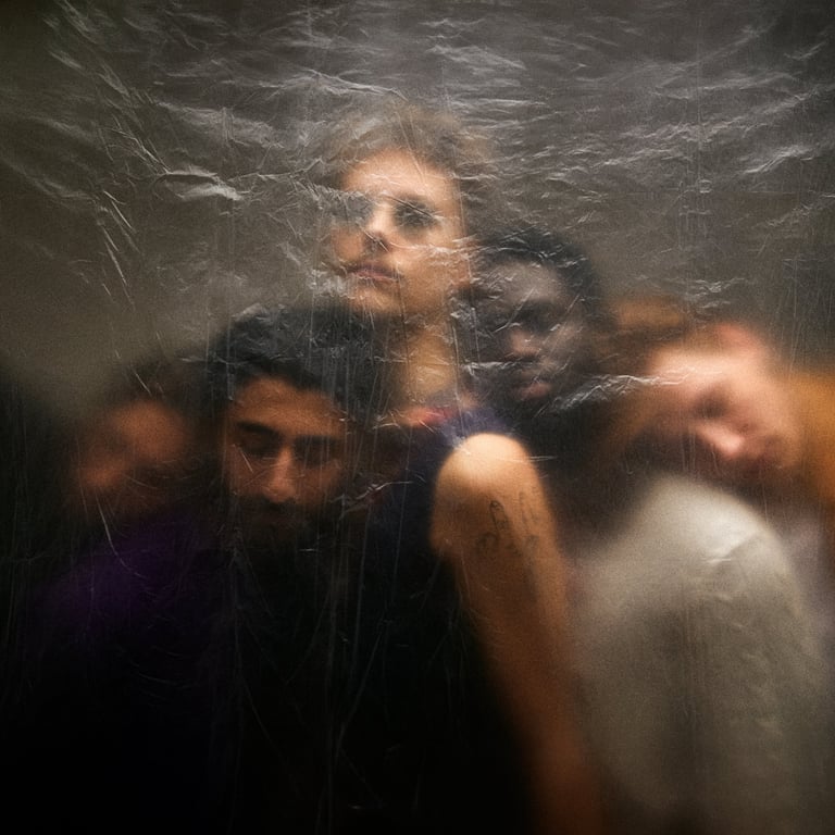 Artistic group portrait of diverse people captured behind a layer of textured, crinkled plastic film.
