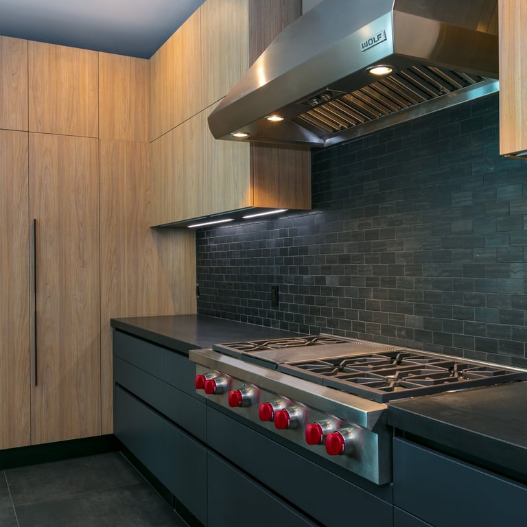 a black countertop and stovetop with a large wooden storage space