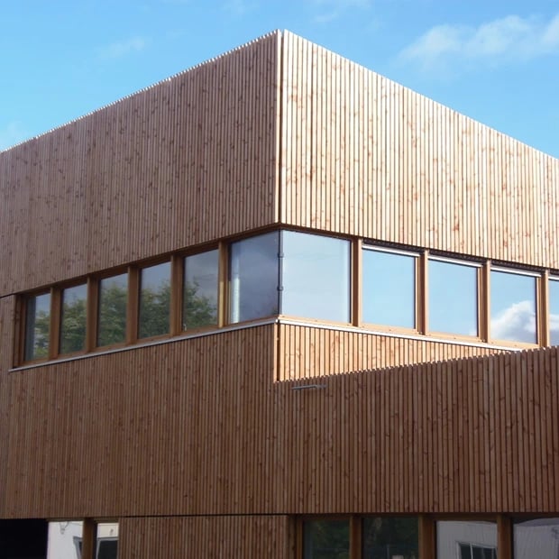 Menuiseries bois gamme Excellence en façade - bâtiment bardage bois, harmonie naturelle