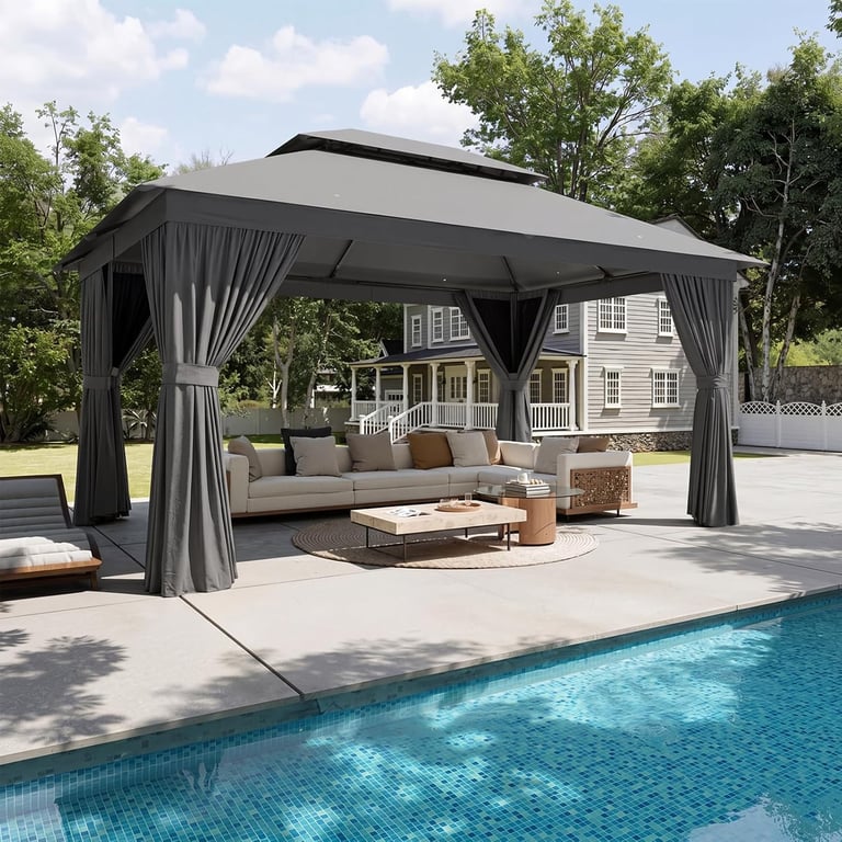 Modern grey outdoor gazebo with curtains over a poolside patio lounge area and sectional sofa.