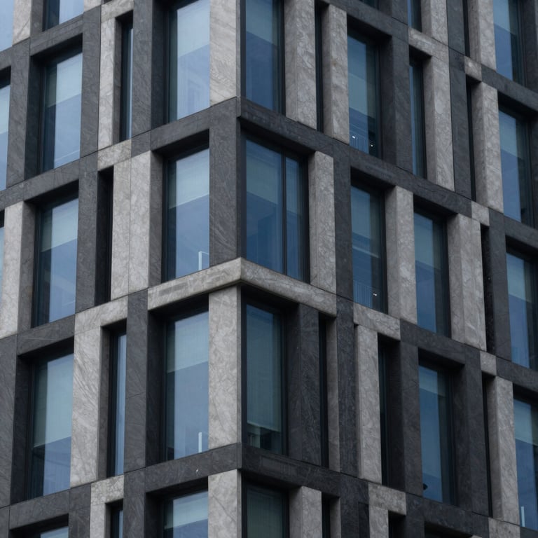 An abstract architectural shot of a modern, intelligent building facade with charcoal grey and deep navy blue glass panels.