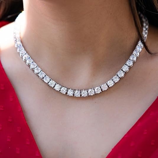 A woman wearing a sparkling round-cut diamond tennis necklace against a red dress.