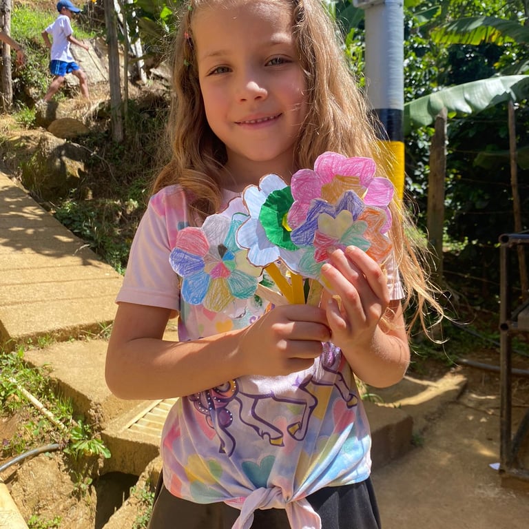una niña sosteniendo una flor de papel