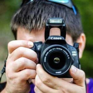 Un photographe avec appareil de marque Canon