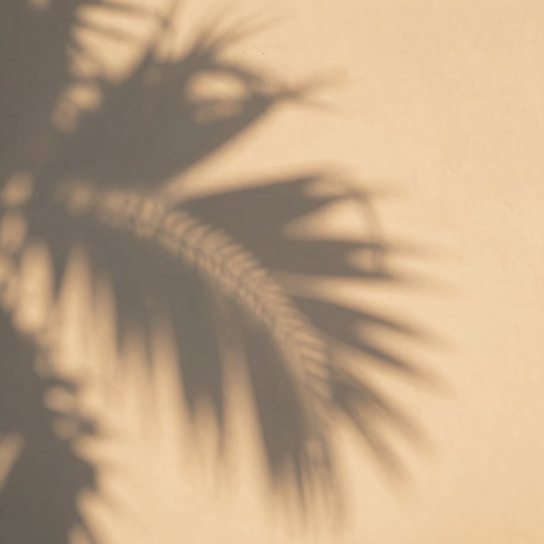 Abstract shadow play of palm leaves on a light beige wall, creating a serene, warm sunset atmosphere.