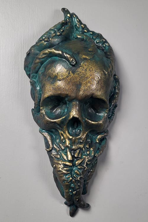 Bronze Cthulhu plaque. A skull with tentacles growing out of it. Teeth grow out of the tentacles to form the bottom jaw.