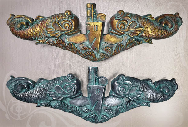 Pic of a gold Submarine Warfare Insignia Officers dolphins over a silver Enlisted dolphin sculpture. 