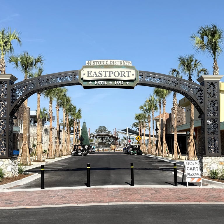 Eastport Town Square entrance sign with palm lined streets and golf car access