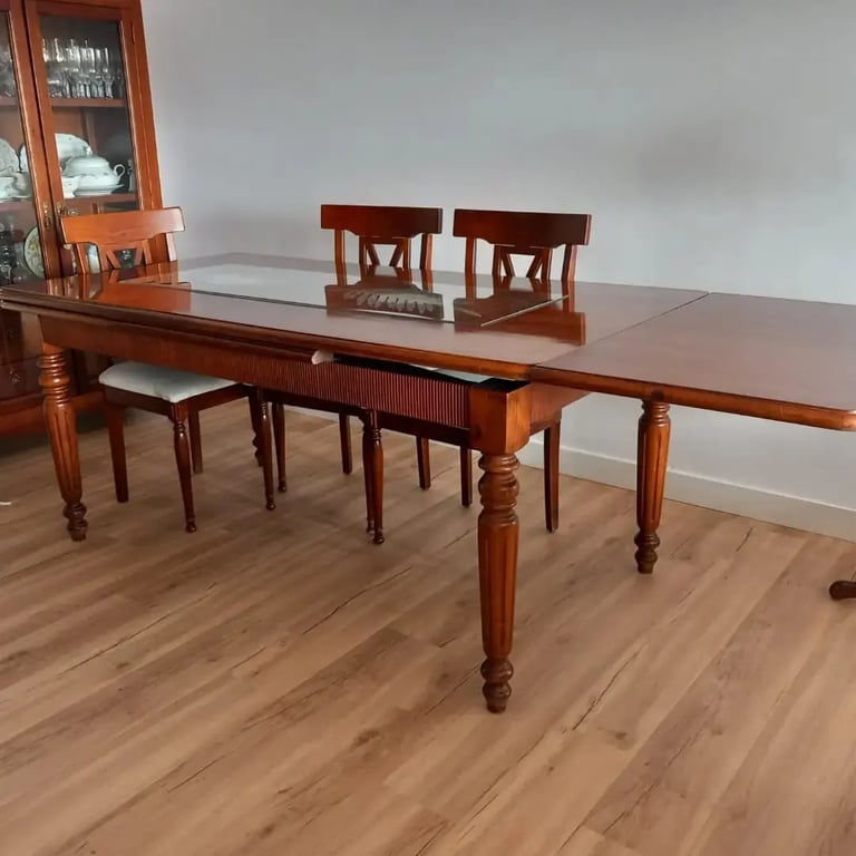 mesa de comedor con tres sillas y una vitrina de madera
