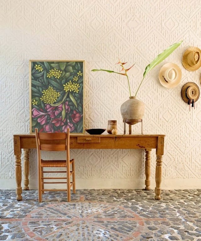 Rustic home interior with a wooden table and a chair and a botanical hand-drawn framed art print