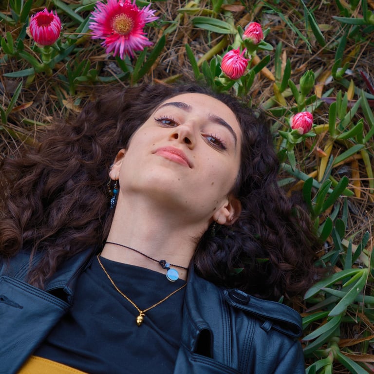 foto di una donna sdraiata su un campo con dei fiori