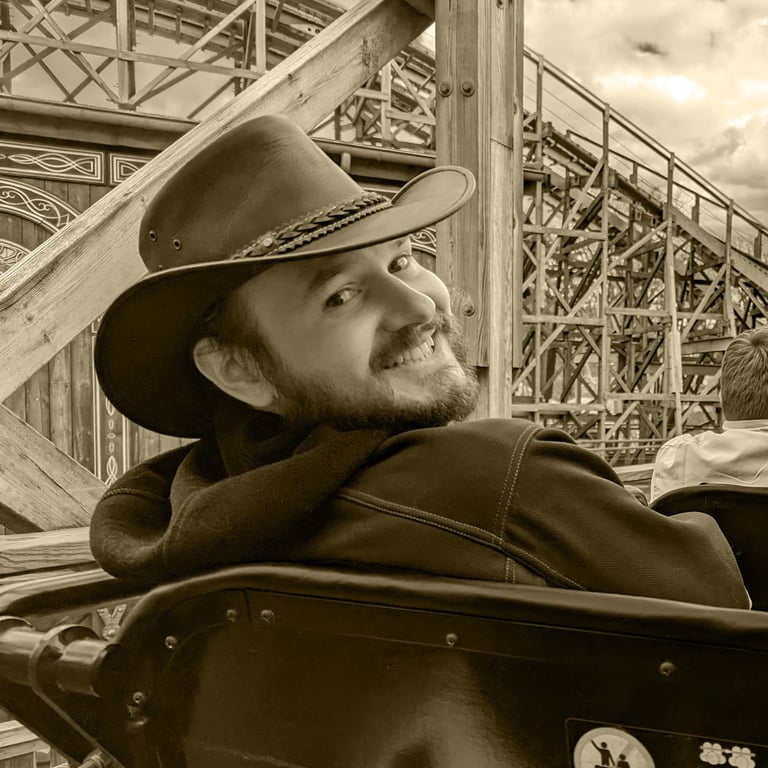 a man in a cowboy hat on a roller coaster, Vaughan Farrar, smiling, friendly, author, happy