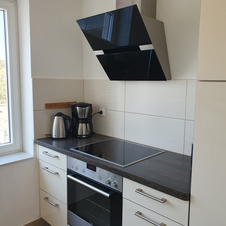 Blick in die Küchenzeile mit Herd, Kaffeemaschine, Wasserkocher