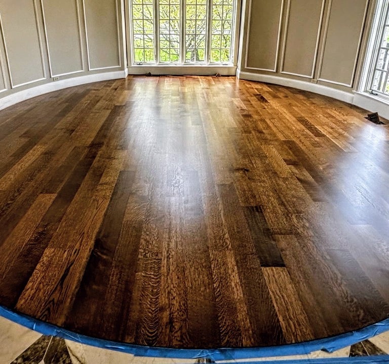 Modern living room featuring refinished natural wide-plank oak hardwood flooring by Go Hard Floor