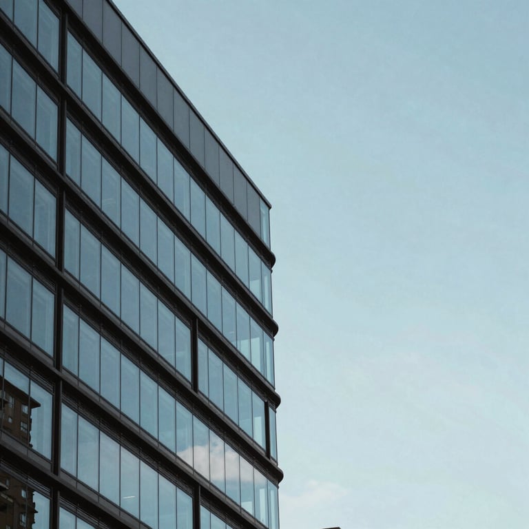 A sleek, modern architecture detail of a glass and steel building under a clear soft blue sky with a minimalist aesthetic.