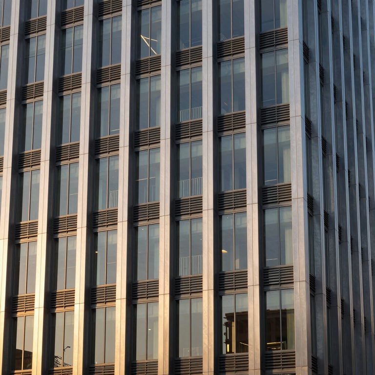 Modern building facade with steel and glass details in a North American city at sunset.