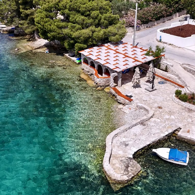Drone shot of Laganini Beach Bar in Nečujam on Šolta with beach and houses in the background