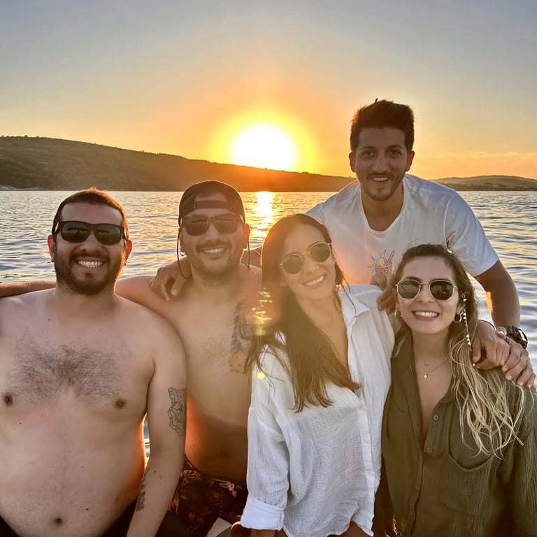 Spanish friends smiling and posing for a photo during a sunset boat tour on the Adriatic Sea from Split