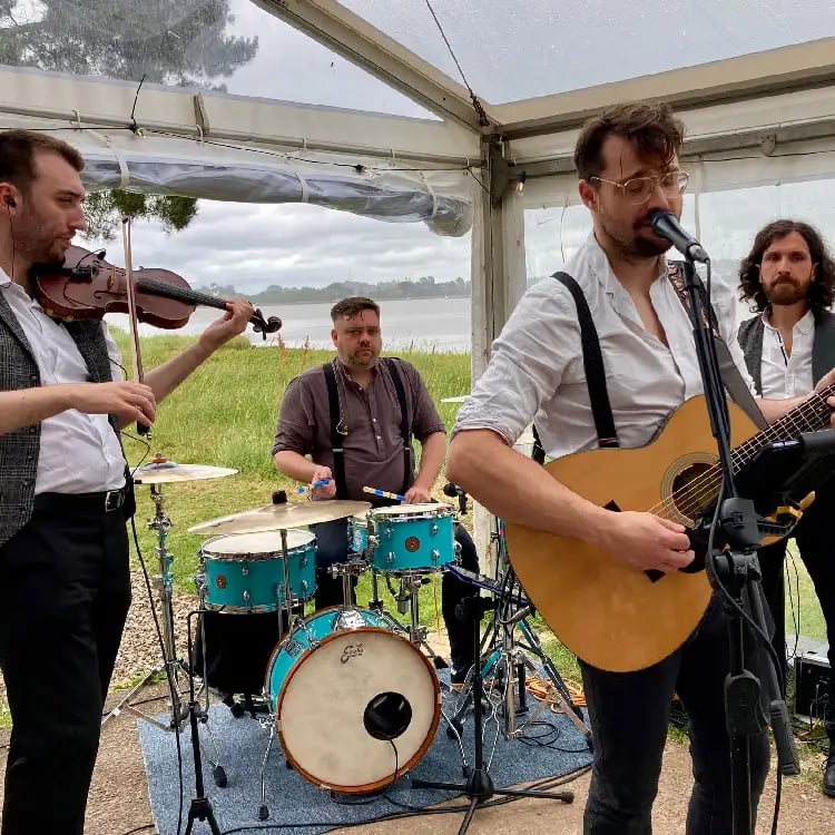 Rowans performing live as a modern wedding ceilidh band with guitar, fiddle, and drums for a packed dancefloor