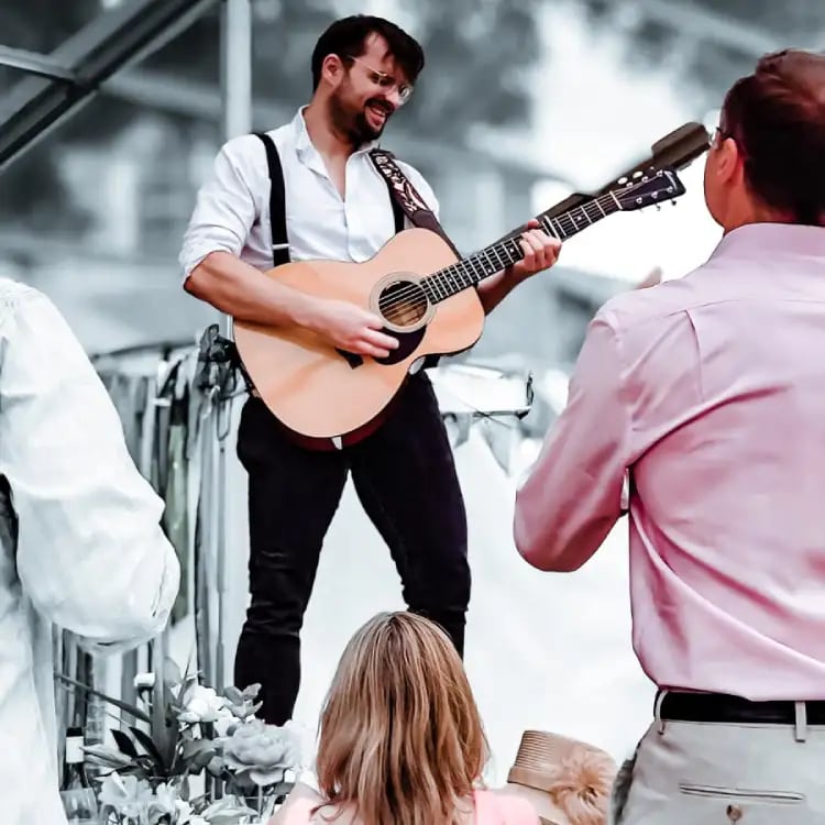 Acoustic guitarist from Rowans performing at a festival-style wedding in Devon and Cornwall