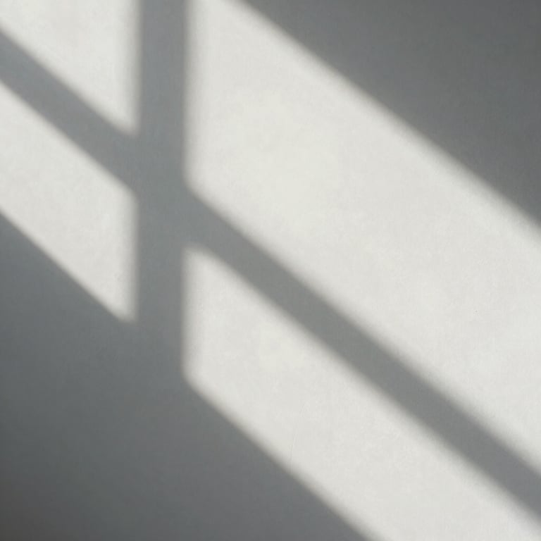 An abstract shot of light and shadow on a ghost white wall, creating clean geometric lines.