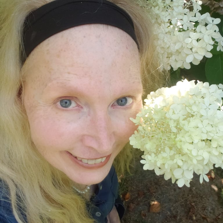 Acupuncturist and author Jean Brannon smiles among hydrangea blossoms.