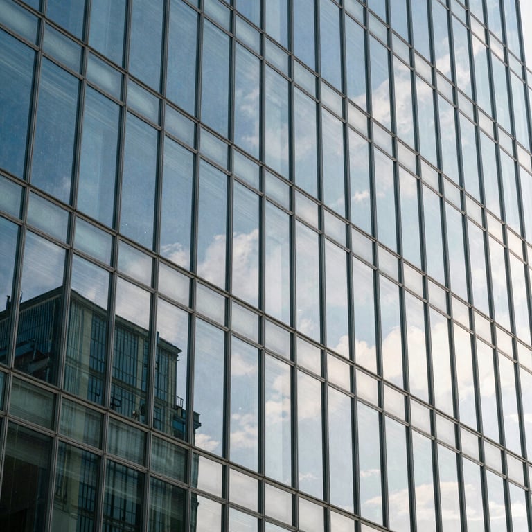 An abstract shot of light reflecting off a glass facade of a modern institution, steel blue and white color scheme.