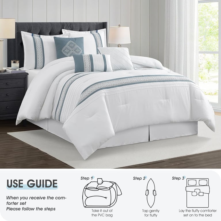 White and blue embroidered comforter set with matching decorative pillows and shams on a modern bed.