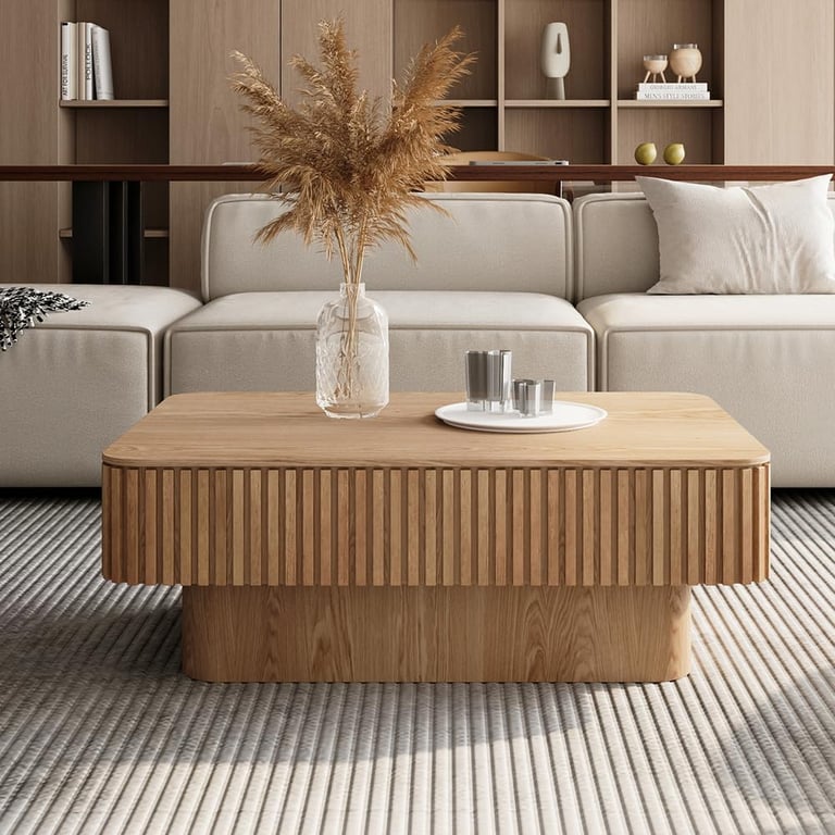 Modern fluted oak coffee table in a minimalist living room with a neutral sofa and pampas grass decor.