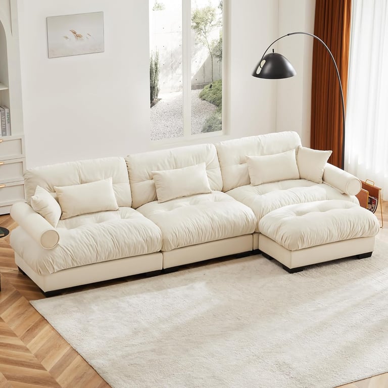 Modern white sectional cloud sofa with plush cushions on a beige rug in a bright living room.