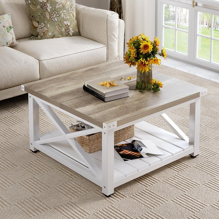 Rustic farmhouse square coffee table with white x-frame base and oak wood top in a cozy living room.