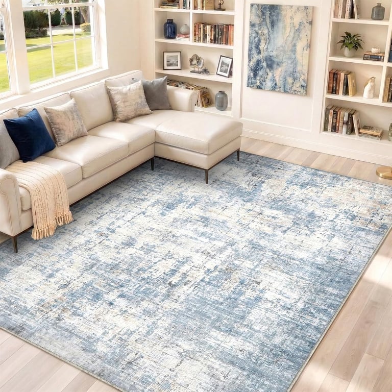 Modern blue and cream distressed area rug in a bright living room with a white sectional sofa.