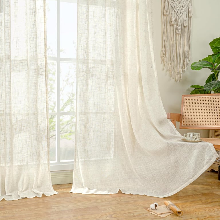 Lightweight linen textured curtains in a bright living room with boho decor and a wooden floor.