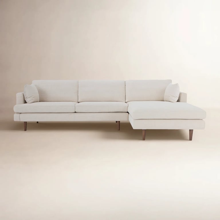 Modern cream-colored sectional sofa with a right-arm chaise and wooden legs for minimalist living room decor.