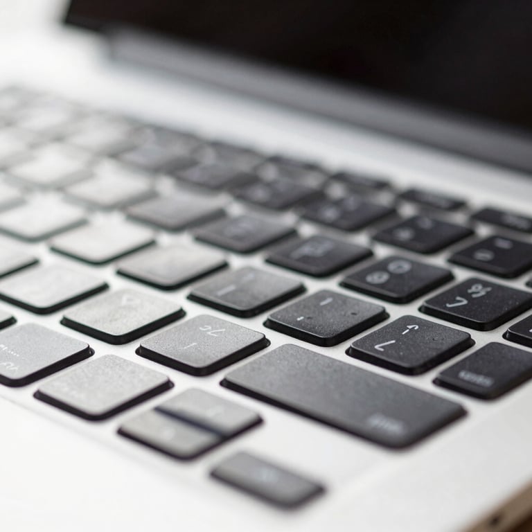 Macro shot of a modern laptop keyboard with light reflecting off the keys.