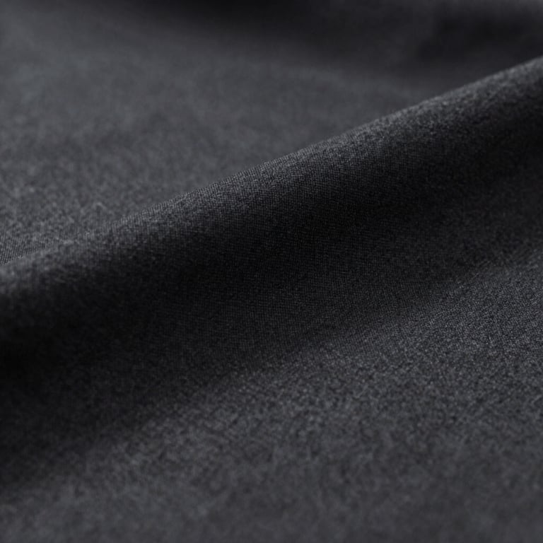 A close-up of high-quality fabric texture in dark charcoal #333333, representing attention to detail.