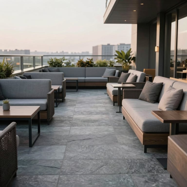 An inviting rooftop lounge area with comfortable modern seating and a soft grey slate floor.