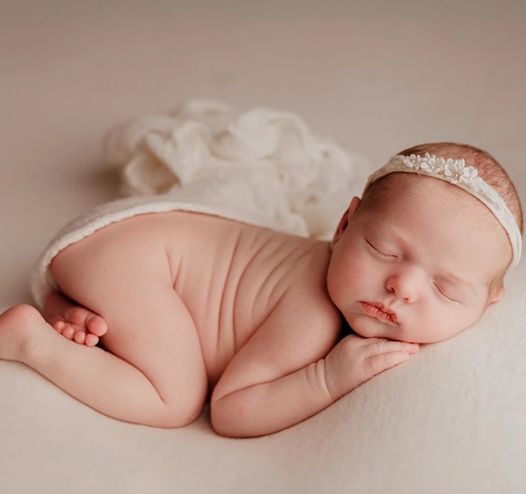 bébé en posing qui dort avec une grande douceur et on voit ses petits pieds