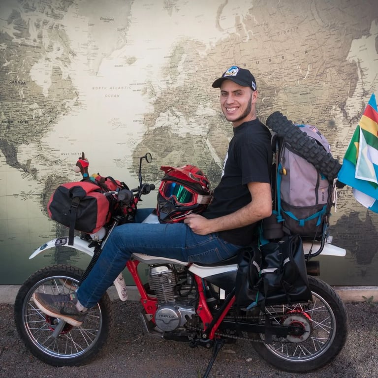 a man sitting on a motorcycle with a backpack on it
