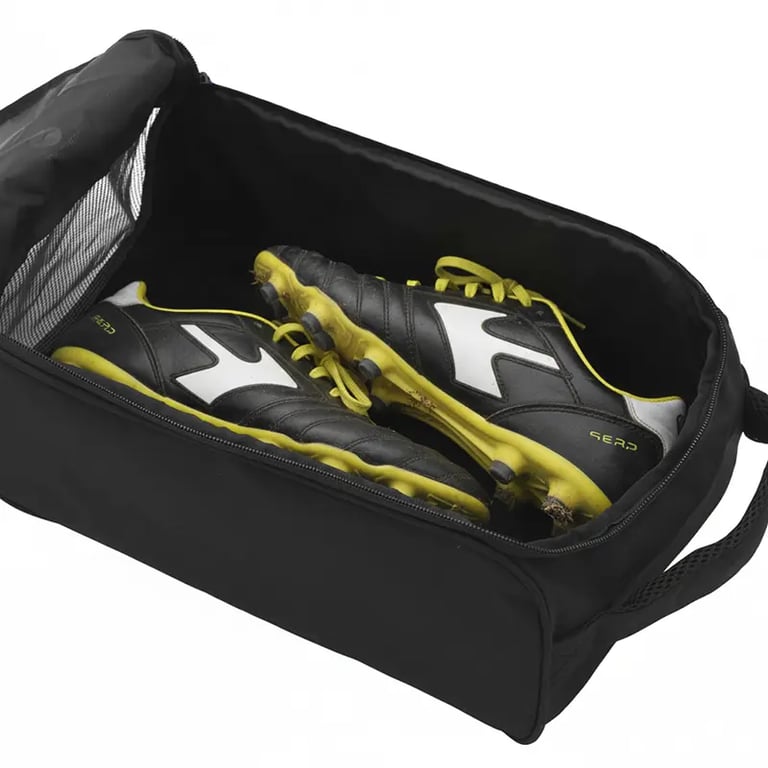 Black and yellow soccer cleats stored inside a black portable sports shoe bag with a mesh pocket.