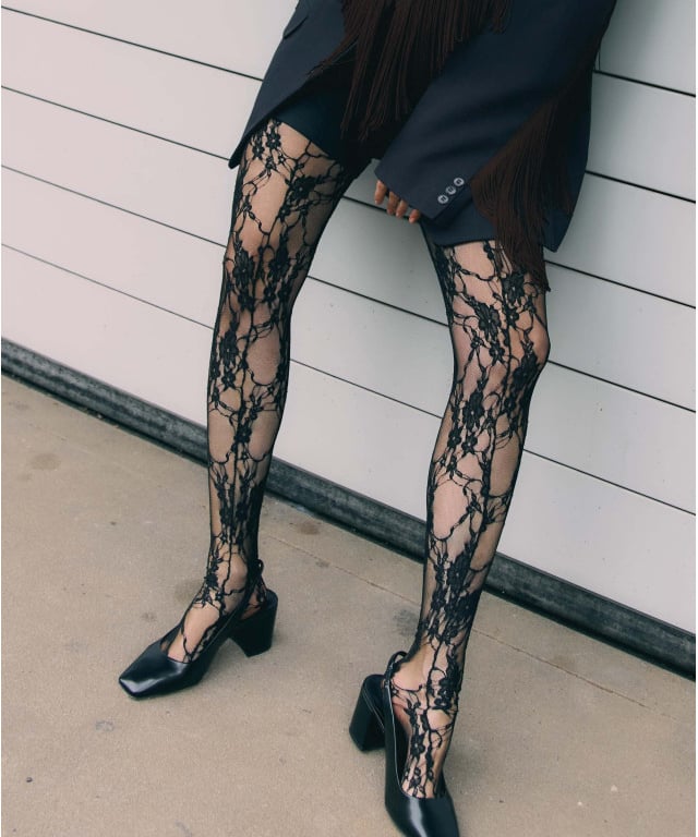 a woman in a black dress and black shoes