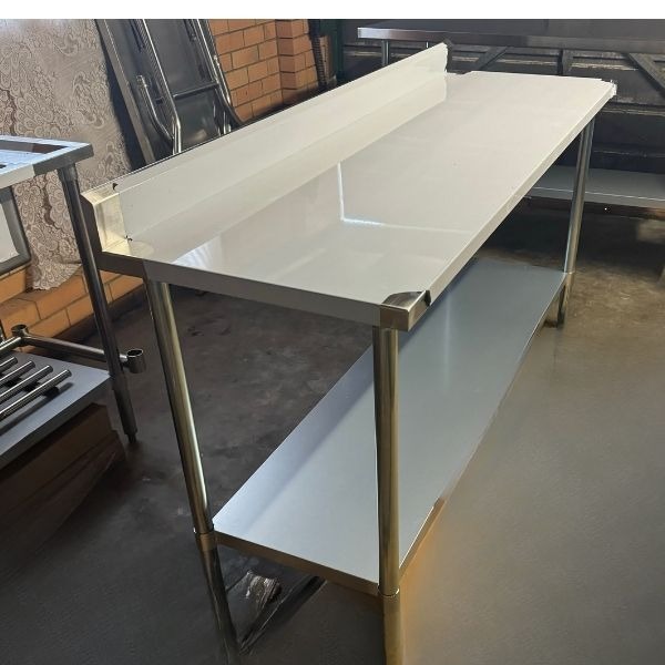 Table Hire: Heavy-duty stainless steel bench with splashback, perfect for commercial use.