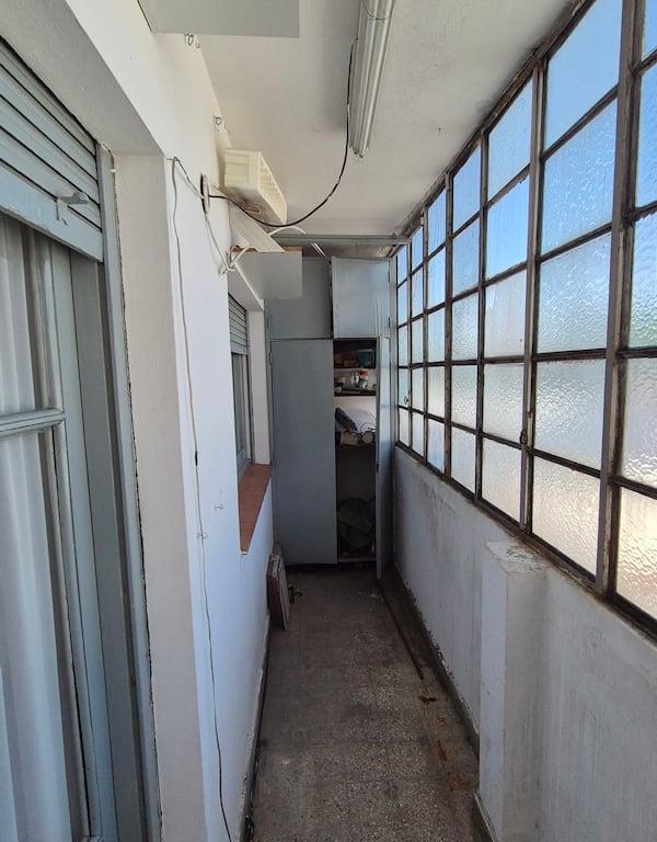 Aberturas antiguas y balcón del departamento de 52 m² en Capital Federal antes de la remodelación 2026