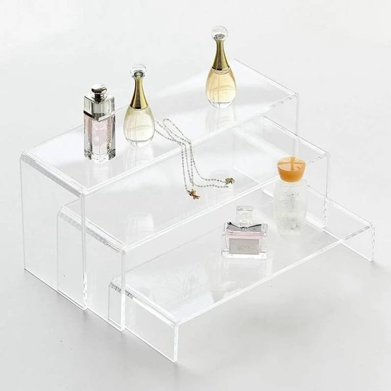 Acrylic risers displaying elegant perfumes and delicate jewelry, enhancing item visibility and decor